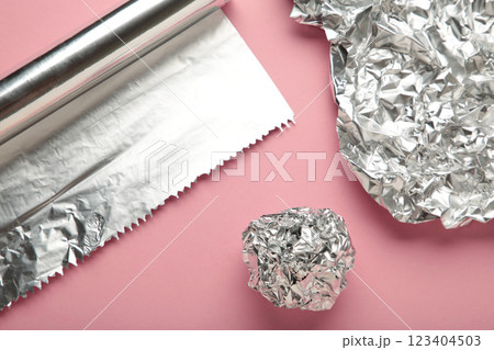 Foil ball with aluminium rolls on pink background. 123404503
