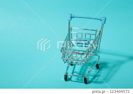Mini shopping trolley with shadow on blue background. Top view Mini shopping trolley with shadow on blue background. Top view 123404572