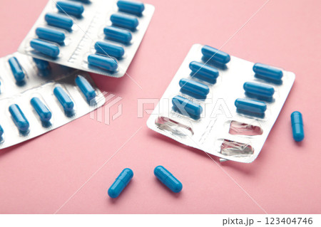 Blister pack with medicines on pink background, top view. Dietary supplements, vitamins for health and body tone. Good mood concept. Blister pack with medicines on pink background, top view. Dietary supplements, vitamins for health and body tone. Good mood concept. 123404746