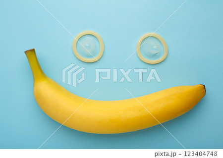 Condom and banana on blue background with copy space 123404748