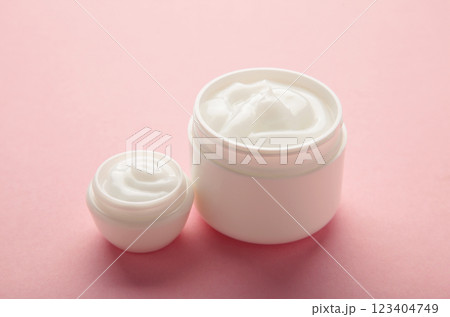 Jar with cream on pink background, space for text 123404749