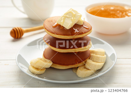 Plate with yummy banana pancakes on white background. 123404766