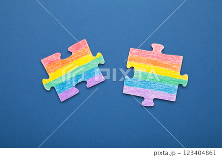 Concept LGBT as a part of society - two puzzle with the coloring of the flag of sexual minorities on dark blue background 123404861