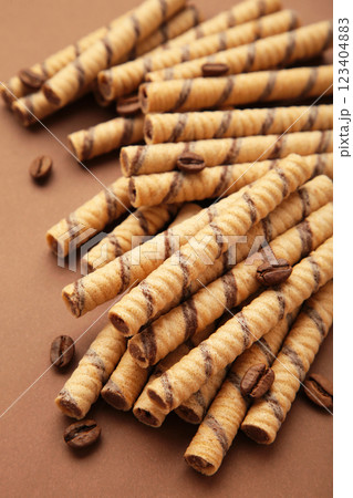 Coffee wafer stick roll with coffee cream on brown background. Vertical photo Coffee wafer stick roll with coffee cream on brown background. Vertical photo 123404883