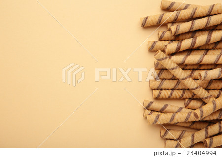 Wafer roll sticks cream rolls on beige background. Space for text Wafer roll sticks cream rolls on beige background. Space for text 123404994