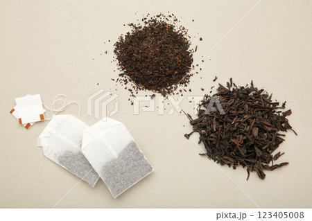 Tea bag and with dry tea leaves on grey background 123405008
