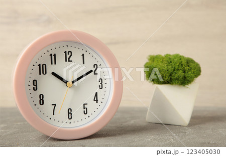 Good morning concept - modern alarm clock and houseplant on light background Good morning concept - modern alarm clock and houseplant on light background 123405030