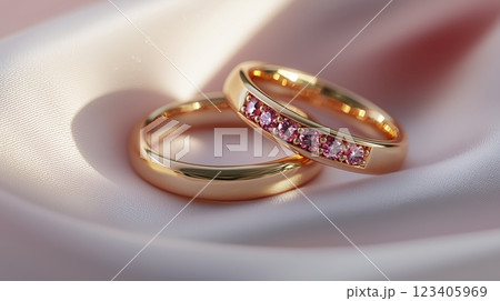 A pair of gold wedding rings on pink fabric, a romantic and dreamy background. 123405969