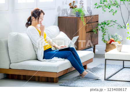 リビングでパソコンを使う若い女性 リビングでパソコンを使う若い女性 123408617