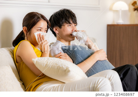 泣きながらテレビを見る男女 泣きながらテレビを見る男女 123408697