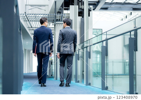 オフィスの廊下を歩くビジネスマン オフィスの廊下を歩くビジネスマン 123408970