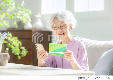 スマホと通帳を見るシニア女性 123409090