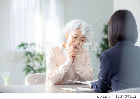 打ち合わせするスーツ姿の女性と高齢者女性 123409112