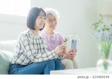 スマホを操作するシニア女性と若い女性 123409149