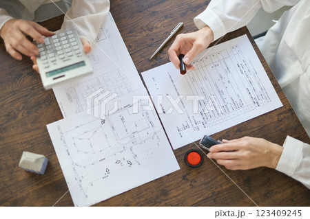 不動産の契約を結ぶ女性2人の手元 123409245