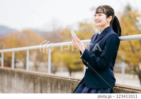 スマホを使う高校生の女の子（アプリ・SNS・インターネット・青春・笑顔） 123411011