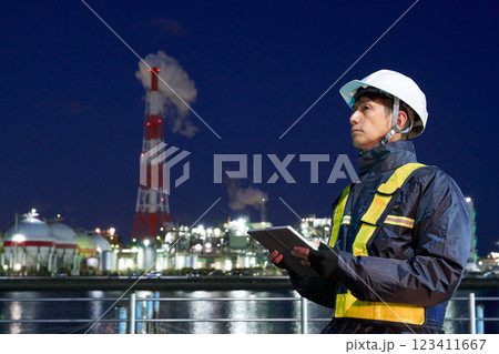 夜の現場で働くヘルメット着用の男性 夜の現場で働くヘルメット着用の男性 123411667