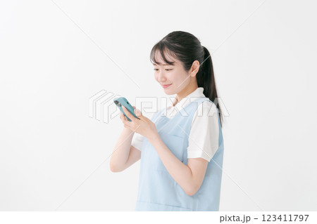 スマホを操作するエプロンの女性 スマホを操作するエプロンの女性 123411797
