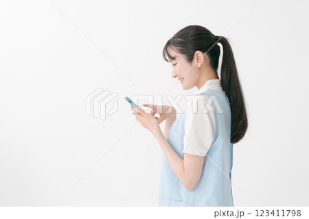 スマホを操作するエプロンの女性 123411798