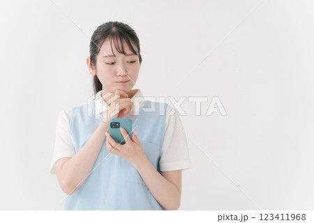 スマホを操作するエプロンの女性 スマホを操作するエプロンの女性 123411968
