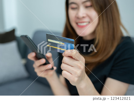 Asian woman while using credit card for shopping online on mobile phone applications. 123412021