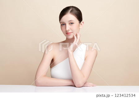 Beautiful young woman with clean fresh skin on beige background, Face care, Facial treatment, Cosmetology, beauty and spa, women portrait. Beautiful young woman with clean fresh skin on beige background, Face care, Facial treatment, Cosmetology, beauty and spa, women portrait. 123412534