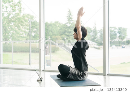 パソコンでオンラインヨガをする若いアジア人男性（伸び・ストレッチ） 123413240