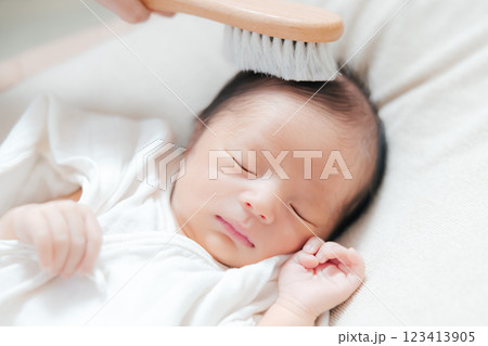 赤ちゃんの髪をベビーブラシで撫でる 赤ちゃんの髪をベビーブラシで撫でる 123413905
