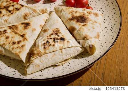 Indulge in Deliciously Grilled Flatbread generously topped with fresh Cherry Tomatoes 123413978