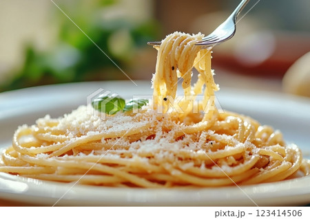 A fork is holding a piece of pasta with cheese on top 123414506