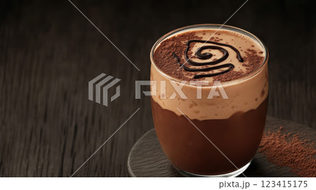 frothy glass of freshly made chocolate milk with swirl of chocolate 123415175