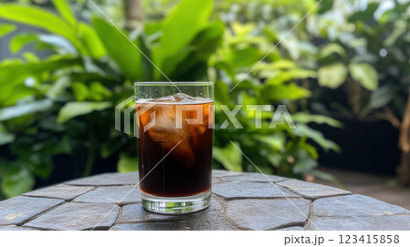 refreshing iced coffee with hint of vanilla syrup, surrounded by lush greenery 123415858