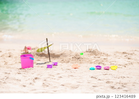 colourful beach toys on tropical beach, Children bucket, spade and other toys on beach against beautiful sea. Summertime and vacation Concept colourful beach toys on tropical beach, Children bucket, spade and other toys on beach against beautiful sea. Summertime and vacation Concept 123416489