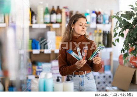 Young woman choosing toothbrush in store 123416693