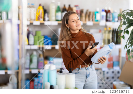 Young woman scanning qr code for detergent Young woman scanning qr code for detergent 123416712