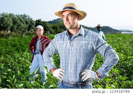 Portrait of satisfied farmer in front of his farm on sunny summer day 123416799