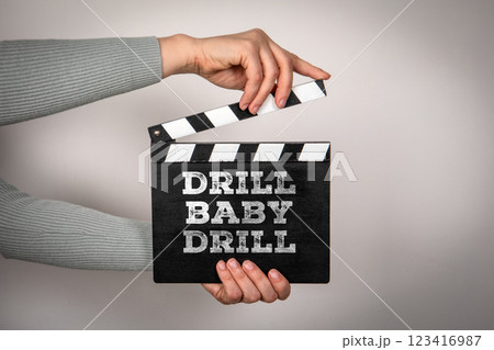 Drill Baby Drill. Female hands holding movie clapper 123416987