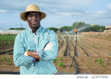 African american farmer standing in field with irrigation system 123417042
