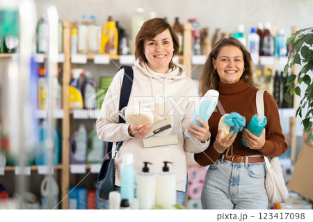 Two women holding shower gel choosing body washcloth in department store 123417098