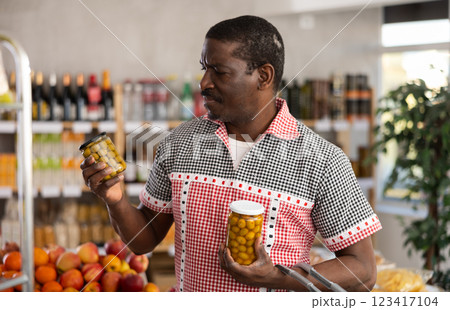Adult man choosing olives in grocery store 123417104
