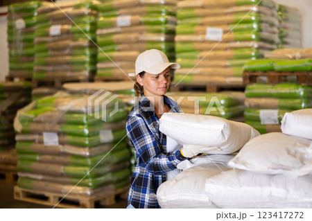 Positive woman worker loading sacks 123417272