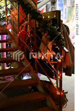 A festive staircase adorned with bright lights and garland, creating a joyful holiday feel 123417364