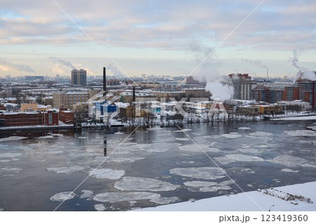 A beautiful winter cityscape showcasing a river alongside various industrial elements 123419360