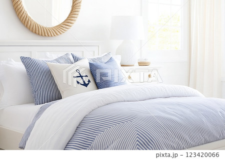 Bright coastal-themed bedroom with anchor pillow and striped bedding 123420066