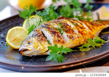 A beautifully grilled Tai sea bream garnished with lemon slices and fresh herbs A beautifully grilled Tai sea bream garnished with lemon slices and fresh herbs 123420084