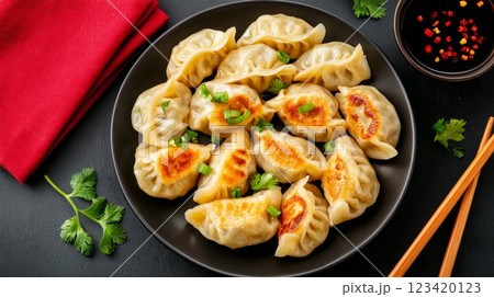 A plate of deliciously arranged Jiaozi dumplings garnished with green onions, served with dipping sauce A plate of deliciously arranged Jiaozi dumplings garnished with green onions, served with dipping sauce 123420123
