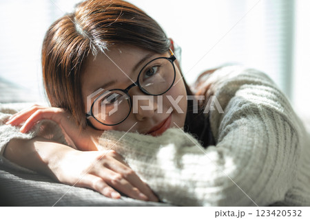 ソファで微笑む眼鏡の女性 ソファで微笑む眼鏡の女性 123420532
