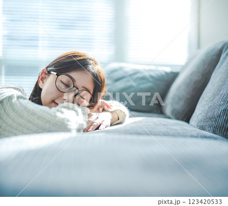 ソファでくつろぐメガネの女性 ソファでくつろぐメガネの女性 123420533