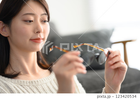 眼鏡を手に持つ女性 眼鏡を手に持つ女性 123420534
