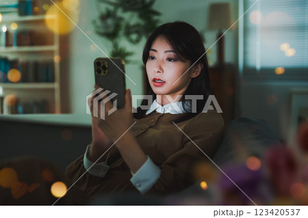 スマートフォンを見つめる夜の女性 123420537